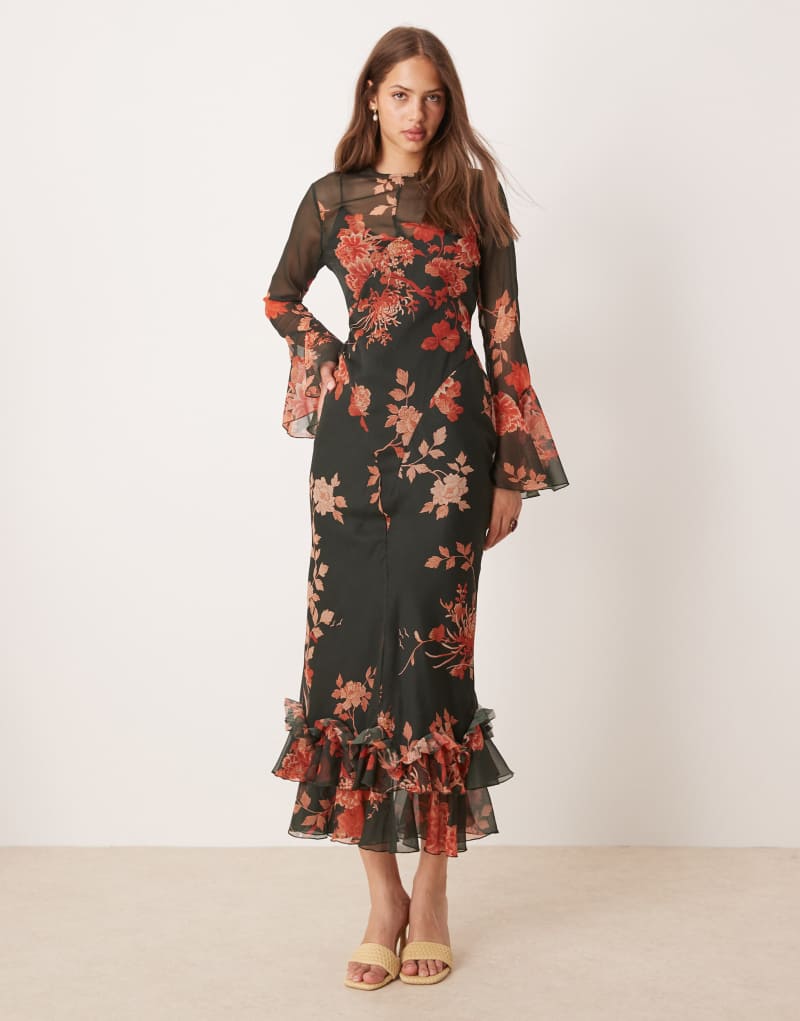 Trend fırfırlı etekli, siyah ve kırmızı çiçek desenli, volanlı kollu maksi elbise.